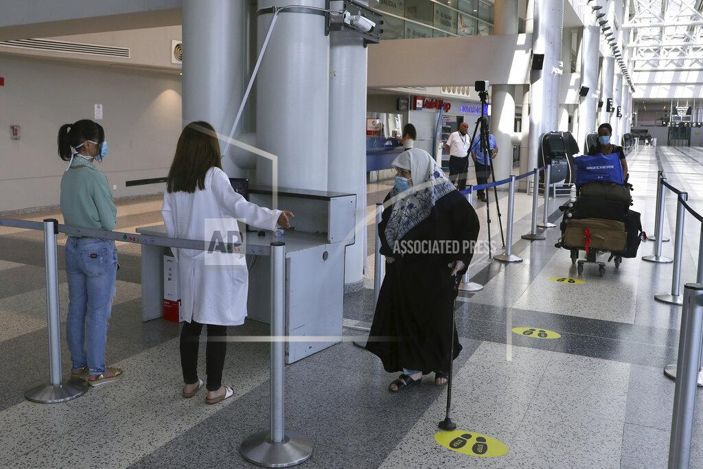 Bilal Hussein Healthcare workers check the temperature of passengers at the departure terminal of the Rafik Hariri International Airport in Beirut, Lebanon, Wednesday, July 1, 2020. Beirut's airport is partially reopening after a three-month shutdown and Lebanon's cash-strapped government is hoping that Thousands of Lebanese expatriates will return for the summer, injecting dollars into the country's sinking economy. (AP Photo/Bilal Hussein)