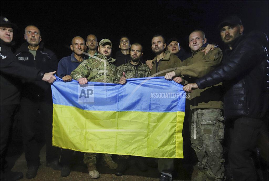Uncredited In this photo provided by the Ukrainian Security service Press Office, Ukrainian soldiers released in a prisoner exchange between Russia and Ukraine, hold the Ukrainian flag close to Chernihiv, Ukraine, late Wednesday, Sept. 21, 2022. Ukraine announced a high-profile prisoner swap early Thursday that culminated months of efforts to free many of the Ukrainian fighters who defended a steel plant in Mariupol during a long Russian siege. (Ukrainian Security service Press Office via AP)