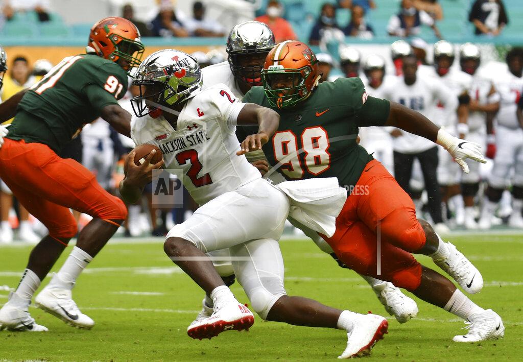 Jim Rassol Jackson State quarterback Shedeur Sanders (2) looks for running room as Florida A&M defensive lineman Stanley Mentor (98) follows on the play in the first quarter of an NCAA college football game, Sunday, Sept. 5, 2021, in Miami Gardens, Fla. (AP Photo/Jim Rassol)