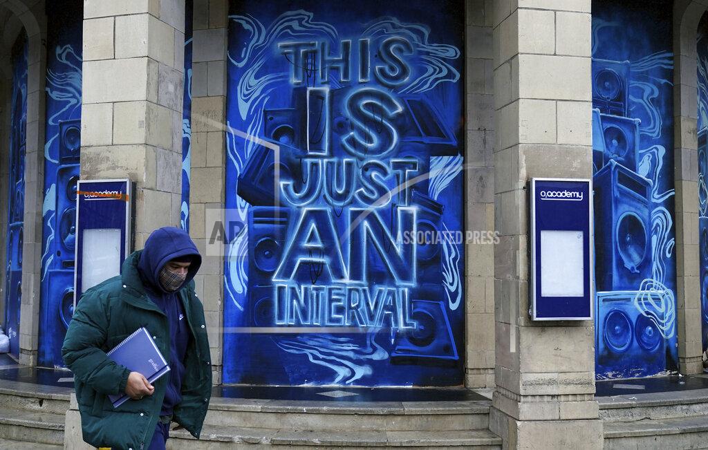 John Walton A man wearing a face mask to prevent the spread of coronavirus walks past the O2 Academy Brixton in London, Wednesday, Jan. 13 2021. England’s health care system may move patients into hotels to ease pressure on hospitals struggling to handle rising COVID-19 admissions. (John Walton/PA via AP)