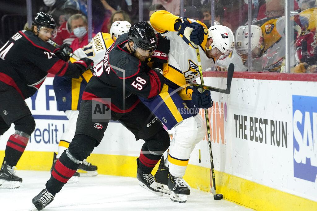 Gerry Broome Carolina Hurricanes defenseman Jani Hakanpaa (58) and Nashville Predators center Yakov Trenin (13) skate for the puck during the first period in Game 5 of an NHL hockey Stanley Cup first-round playoff series in Raleigh, N.C., Tuesday, May 25, 2021. (AP Photo/Gerry Broome)