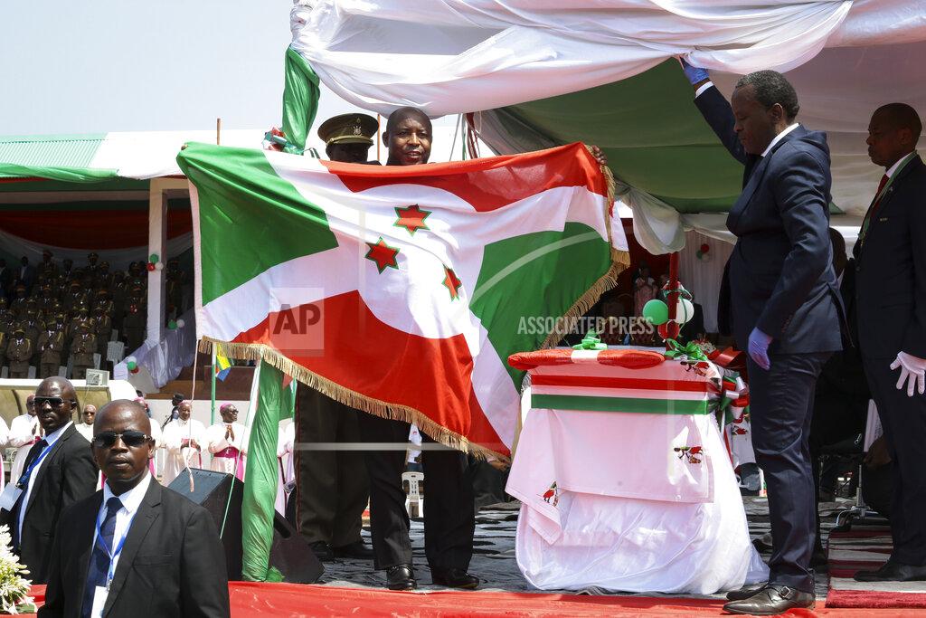 Burundi's President Evariste Ndayishimiye holds the national flag after his inauguration in Gitega, Burundi Thursday, June 18, 2020. President Evariste Ndayishimiye took power two months early after the abrupt death of his predecessor Pierre Nkurunziza. (AP Photo/Berthier Mugiraneza)