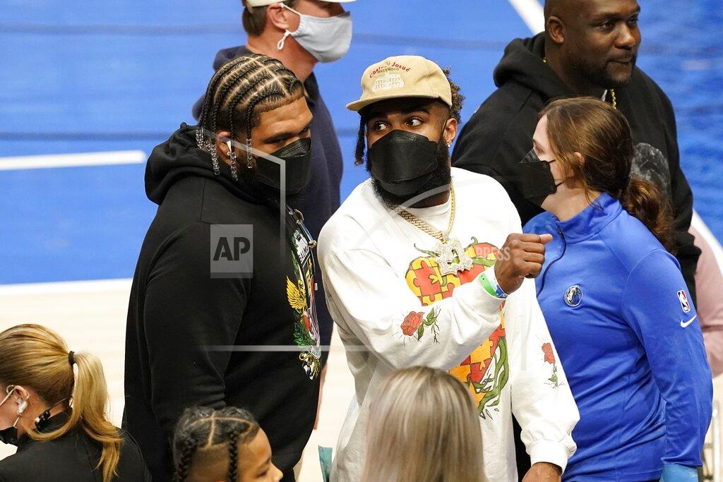 Tony Gutierrez Dallas Cowboys players La'el Collins, center left, and Ezekiel Elliott, center right, talk as they leave after an NBA basketball game between the Los Angeles Lakers and Dallas Mavericks in Dallas, Wednesday, Dec. 15, 2021. (AP Photo/Tony Gutierrez)