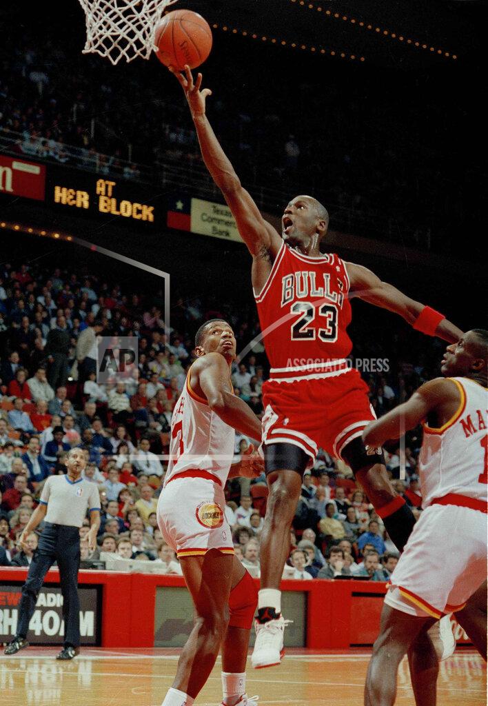 David Scarbrough FILE - In this Jan. 3, 1991, file photo, Michael Jordan (23) of the Chicago Bulls drives the lane for a finger roll lay-up over Otis Thorpe, left, and Vernon Maxwell, right, of the Houston Rockets in the first half in Houston, Texas. Picking the car number for Michael Jordan's new NASCAR team was a slam dunk: Bubba Wallace will drive the No. 23 car when the team makes its debut next season. (AP Photo/David Scarbrough, File)