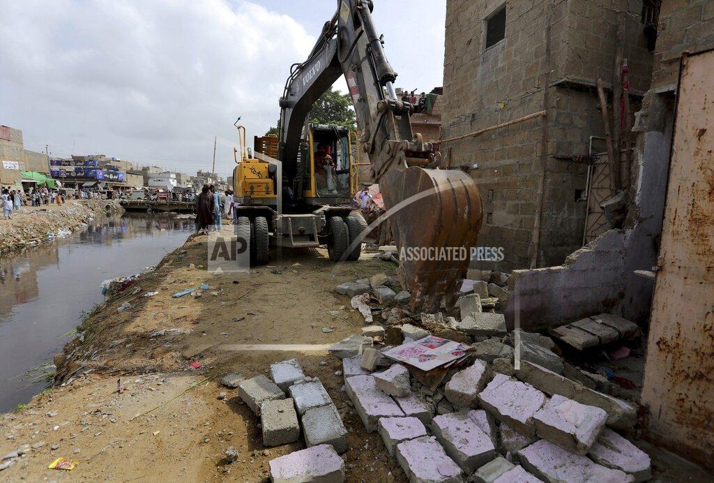 Fareed Khan Local authorities use heavy machinery to demolish illegal construction alongside a drainage canal which saw flooding last week due to heavy monsoon rains, in Karachi, Pakistan, Wednesday, Sept. 2, 2020. Flash floods triggered by heavy rains killed some people and damaged scores of houses in Pakistan's scenic northwestern Swat Valley, a spokesman said Wednesday, as rescuers assisted residents in the port city of Karachi where last week's rains wreaked havoc that killed dozens. (AP Photo/Fareed Khan)