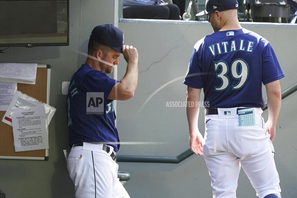 Ted S. Warren Seattle Mariners pitching coach Pete Woodworth, left, and major league field coordinator Carson Vitale (39) linger in the dugout after the team's baseball game against the Oakland Athletics, Wednesday, May 25, 2022, in Seattle. The Athletics won 4-2. (AP Photo/Ted S. Warren)