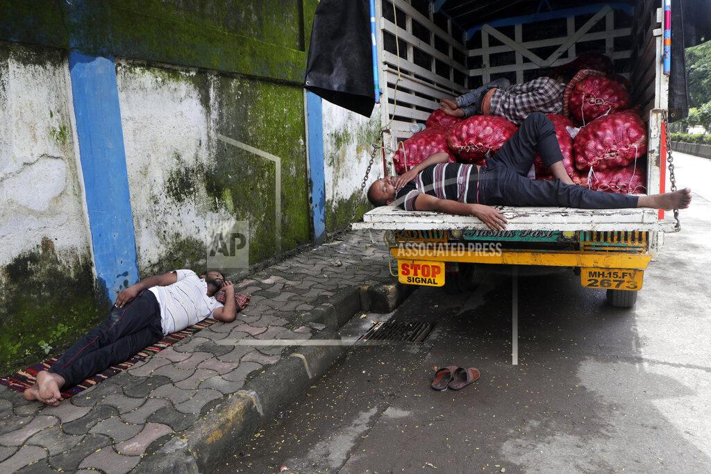 Rajanish Kakade People sleep by a truck carrying vegetables in Mumbai, India, Friday, Sept. 25, 2020. In the April-June quarter, government figures show, activity in trade, hotels, transport, construction and communication declined by nearly half from a year earlier. Manufacturing contracted by about 40%. Despite the strains, there are some bright spots. Agriculture overall is growing at a 3.4% pace. With good monsoon rains, India might attain a record of 301 million metric tons of food-grain output, including wheat, rice, oil seeds, lentils and mustard, in the 2020-21 financial year, 4 million metric tons more than in 2019-20. (AP Photo/Rajanish Kakade)