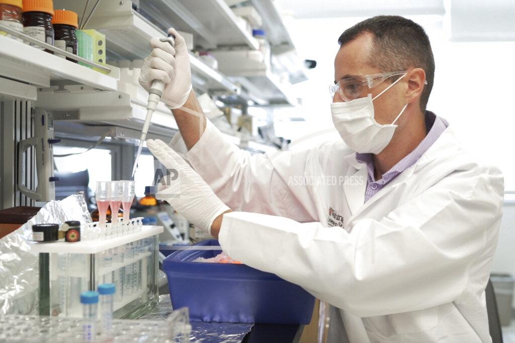 Huy Mach In this image from video provided by Washington University, researcher Nicolas Barthelemy works on a p-tau217 test for Alzheimer's disease at a laboratory in St. Louis, Mo., on Monday, July 27, 2020. Several companies and universities have developed versions of these tests, which look for a form of tau protein, one of the substances that can build up and damage the brains of people with Alzheimer’s. (Huy Mach/University of Washington via AP)