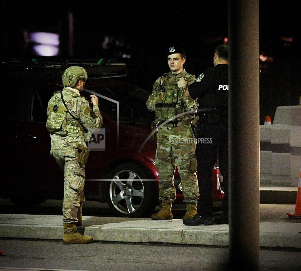 Marshall Gorby A police officer and members of the military talk near an entrance to Wright-Patterson Air Force Base, Ohio, near Dayton, Thursday, Sept. 9, 2021. The base was put on lockdown to investigate reports of a shooter on the campus, according to the airbase. (Marshall Gorby/Dayton Daily News via AP)