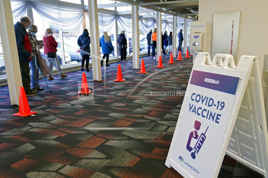Jim Mone People line up for a vaccination at the Earle Brown Heritage Center, Thursday, Jan. 21, 2021, in Brooklyn Center, Minn. Minnesota on Thursday opened up nine locations for coronavirus vaccinations as part of a pilot program reserved for people 65 and over. Demand for the program was exceptionally heavy, with slots for the few available doses quickly filling after registration opened two days earlier. (AP Photo/Jim Mone)