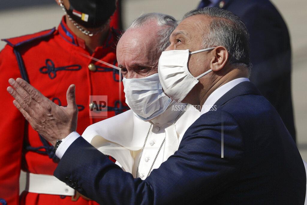 Andrew Medichini Pope Francis is greeted by Iraqi Prime Minister Mustafa al-Kadhimi upon his arrival at Baghdad's international airport, Iraq, Friday, March 5, 2021. Pope Francis heads to Iraq on Friday to urge the country's dwindling number of Christians to stay put and help rebuild the country after years of war and persecution, brushing aside the coronavirus pandemic and security concerns. (AP Photo/Andrew Medichini)