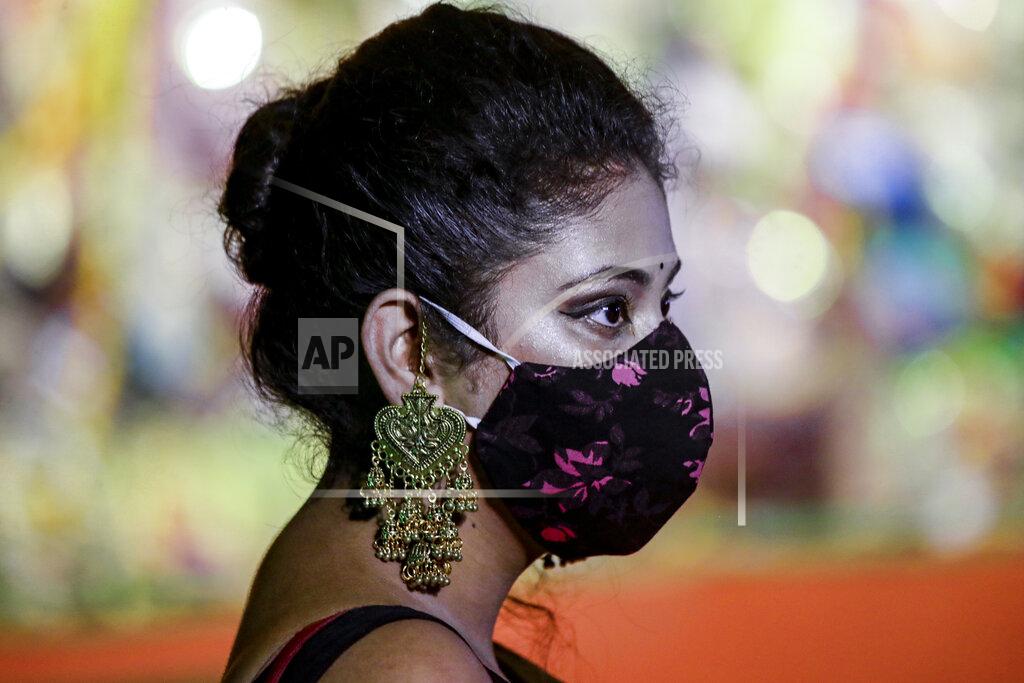 Bikas Das A Hindu devotee wearing face mask and ornaments visits an almost deserted worship venue of Hindu goddess Durga during Durga Puja, the biggest festival of the region, in Kolkata, India, Sunday, Oct. 25, 2020. The Hindu festival season is traditionally laced with an unmatched fanfare and extravaganza, with socializing being the hallmark of the celebration. But because of the coronavirus pandemic this year's festivities have started on a pale note. (AP Photo/Bikas Das)