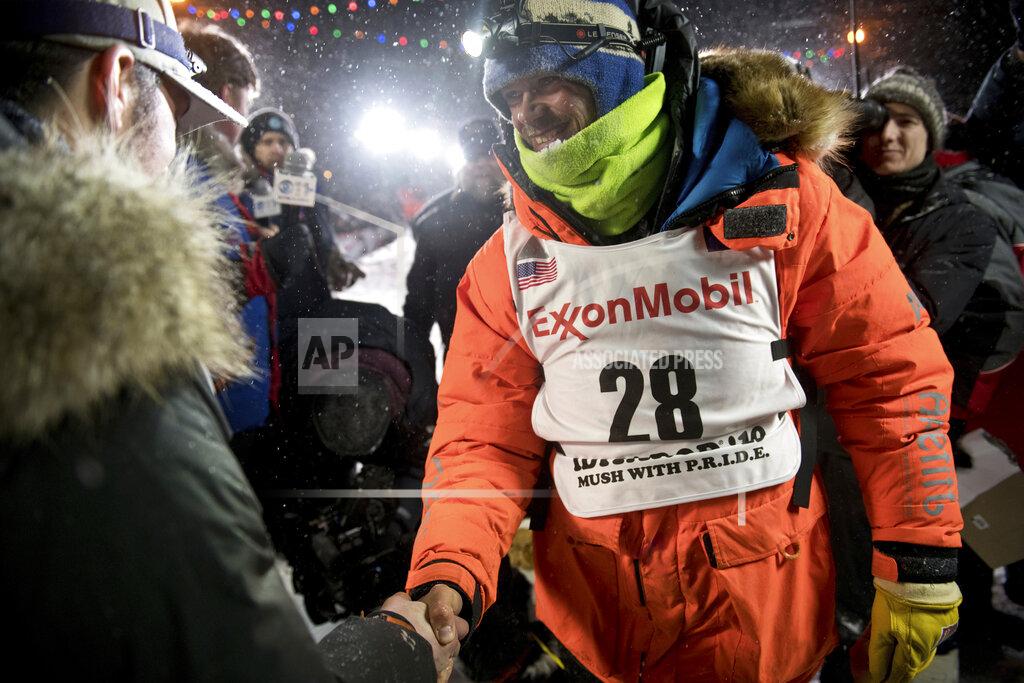 Marc Lester FILE - In this March 13, 2019, file photo, Joar Leifseth Ulsom, right, wearing a bib with ExxonMobil lettering on it, congratulates Peter Kaiser on his win in the Iditarod Trail Sled Dog Race in Nome, Alaska. The world's most famous sled dog race has lost another major sponsor as the Iditarod prepares for a scaled-back version of this year's race because of the pandemic, officials said Thursday, Jan. 21, 2021. ExxonMobil confirmed to The Associated Press that the oil giant will drop its sponsorship of the race. (Marc Lester/Anchorage Daily News via AP, File)