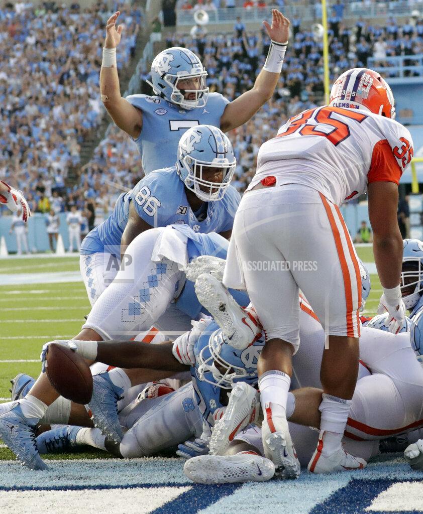 Chris Seward North Carolina Tar Heels's Sam Howell (7) signals for a touchdown as J.C. Chalk (25) crosses the line to score late in the fourth quarter of an NCAA college football game against Clemson in Chapel Hill, N.C., Saturday, Sept. 28, 2019. North Carolina's Carl Tucker (86) and Clemson Justin Foster (35) are also in on the play. (AP Photo/Chris Seward)