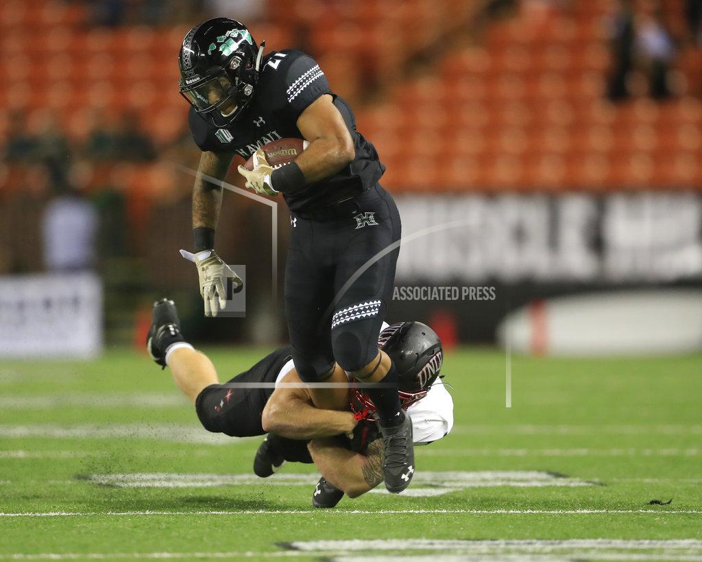 Marco Garcia Hawaii running back Fred Holly III (21) gets pulled down by UNLV linebacker Bailey Laolagi (48) uring the fourth quarter of an NCAA college football game, Saturday, Nov. 17, 2018, in Honolulu. Hawaii defeated UNLV 35-28. (AP Photo/Marco Garcia)