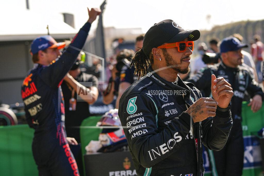 Francisco Seco Mercedes driver Lewis Hamilton of Britain gestures as Red Bull driver Max Verstappen of the Netherlands celebrates in background after clinching the pole position following the qualifying session for Sunday's Formula One Dutch Grand Prix at the Zandvoort racetrack, Netherlands, Saturday, Sept. 4, 2021. Hamilton set the second fastest time. (AP Photo/Francisco Seco, Pool)