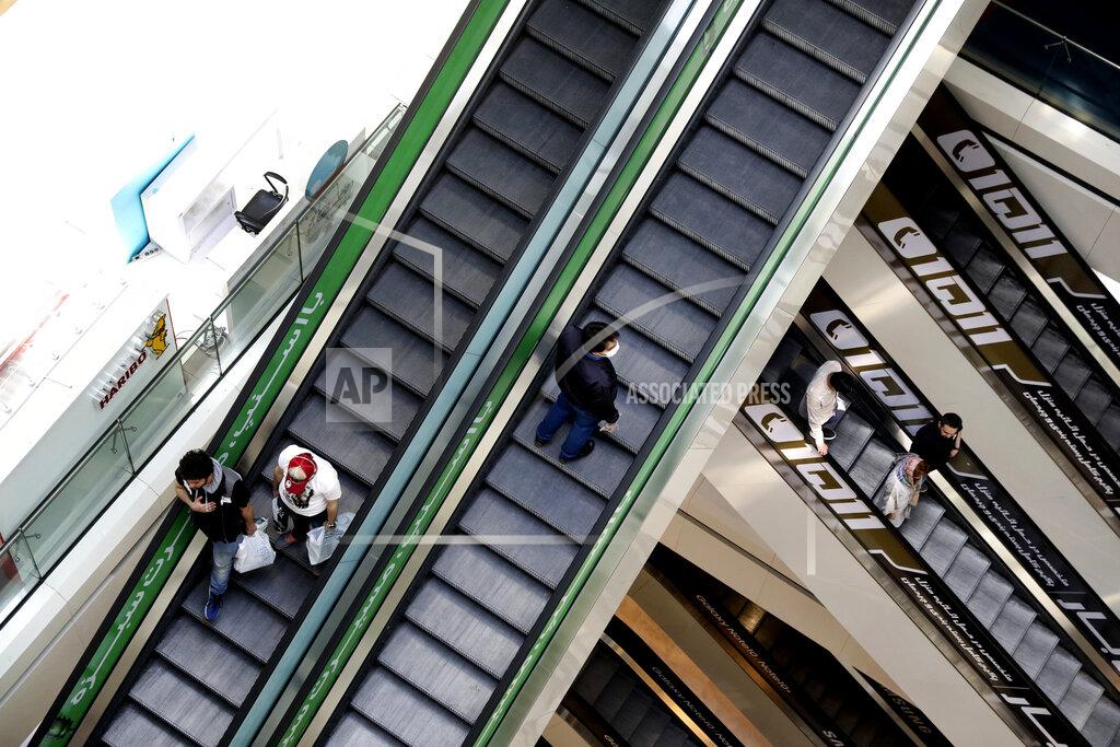 People ride escalators at the Kourosh Shopping Center in Tehran, Iran, Monday, April 20, 2020. Iran on Monday began opening intercity highways and major shopping centers to stimulate its sanctions-choked economy, gambling that it has brought under control its coronavirus outbreak — one of the worst in the world — even as some fear it could lead to a second wave of infections. (AP Photo/Vahid Salemi)