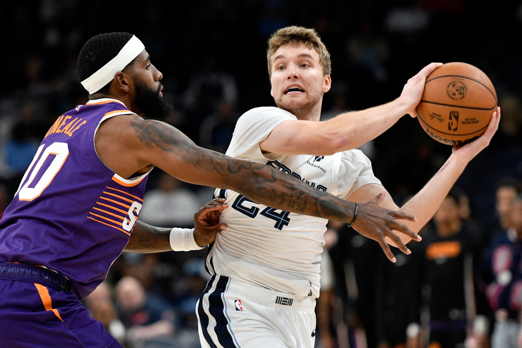 Memphis Grizzlies guard Cam Spencer (24) handles the ball against Phoenix Suns forward Royce O'Neale (00) in the first half of an NBA basketball game Wednesday, Jan. 7, 2026, in Memphis, Tenn. (AP Photo/Brandon Dill)