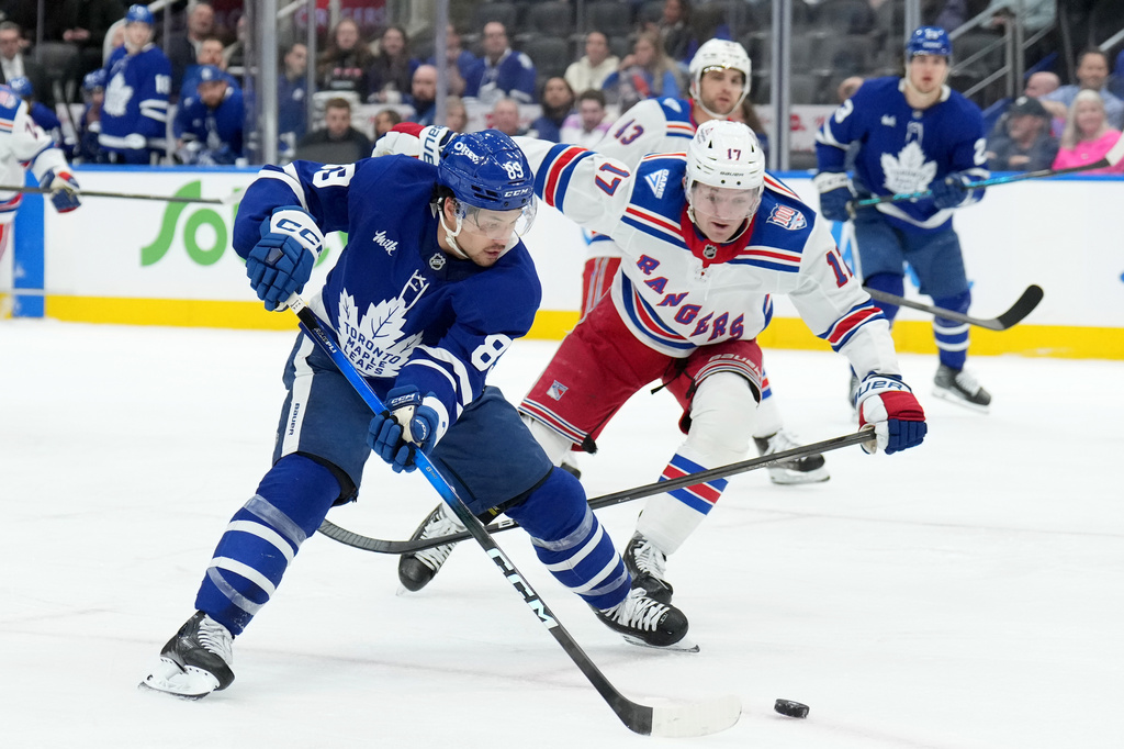 Toronto Maple Leafs forward Nicholas Robertson (89) drives the puck past New York Rangers defenceman Will Borgen (17) during the second period of an NHL hockey game in Toronto, Wednesday, March 25, 2026. (Nathan Denette/The Canadian Press via AP)