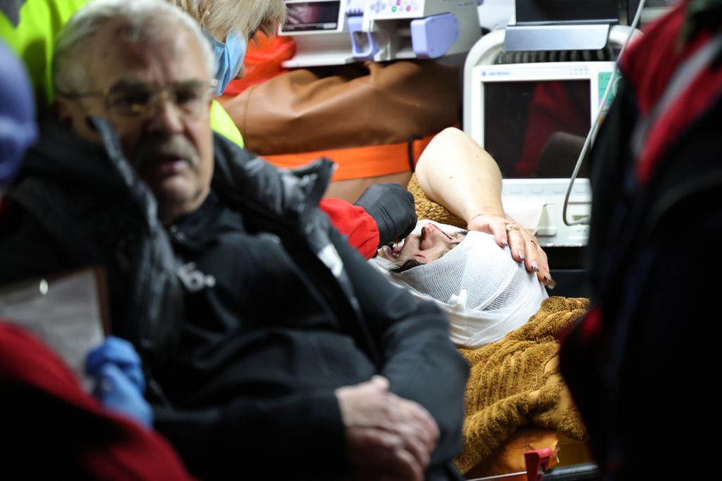 Paramedics treat people who were injured after a Russian attack on a residential neighborhood in Zaporizhzhia, Ukraine, Wednesday, Nov. 26, 2025. (AP Photo/Kateryna Klochko)