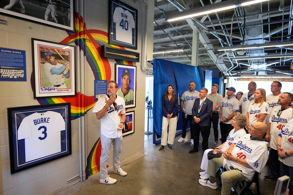 Dr. Greg Baker, left, widower of Billy Bean, speaks during a ceremony prior to a baseball game to unveil a tribute to LGBTQ+ trailblazers and former Los Angeles Dodgers players Bean and Glenn Burke, who were among the first professional athletes to identify as gay, Friday, June 5, 2026, in Los Angeles. (AP Photo/Mark J. Terrill)
