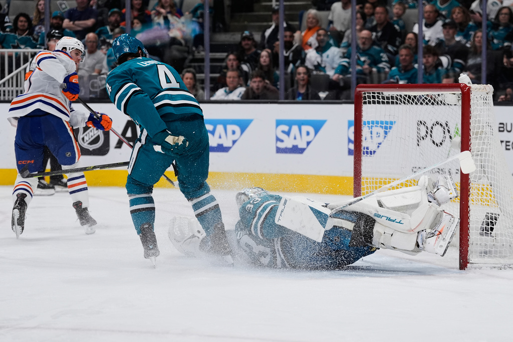 San Jose Sharks goaltender Alex Nedeljkovic, right, is unable to stop a goal by Edmonton Oilers center Connor McDavid, left, during the second period of an NHL hockey game, Wednesday, April 8, 2026, in San Jose, Calif. (AP Photo/Godofredo A. Vásquez)