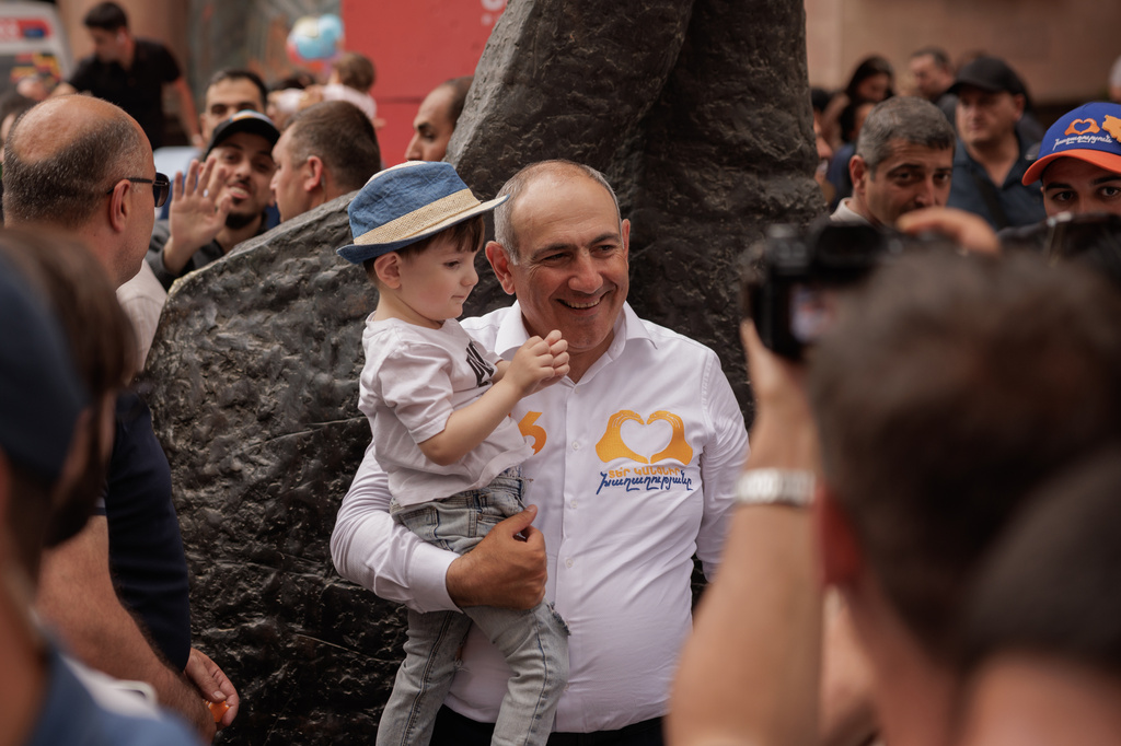 Armenian Prime Minister Nikol Pashinyan holds a child as he walks on Northern Avenue in Yerevan, Armenia, Monday, June 1, 2026, during public celebrations marking International Children's Day. (AP Photo/Anthony Pizzoferrato)