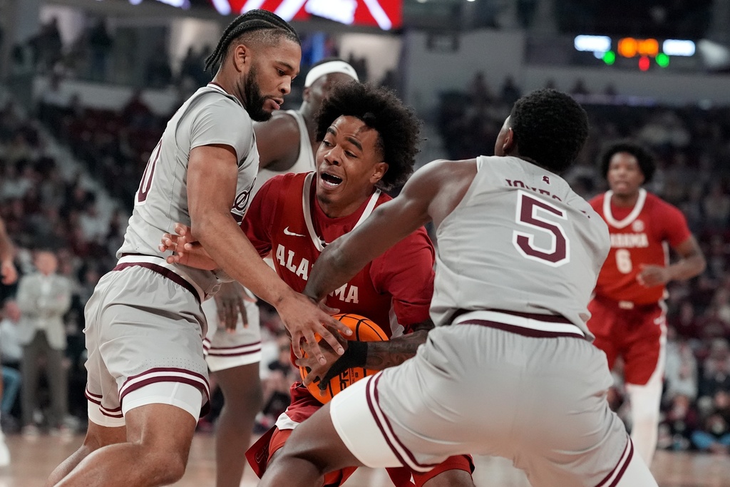 Alabama guard Labaron Philon, center, is pressured by Mississippi State guards Jayden Epps, left, and Shawn Jones Jr. (5) during the first half of an NCAA college basketball game, Tuesday, Jan. 13, 2026, in Starkville, Miss. (AP Photo/Rogelio V. Solis)