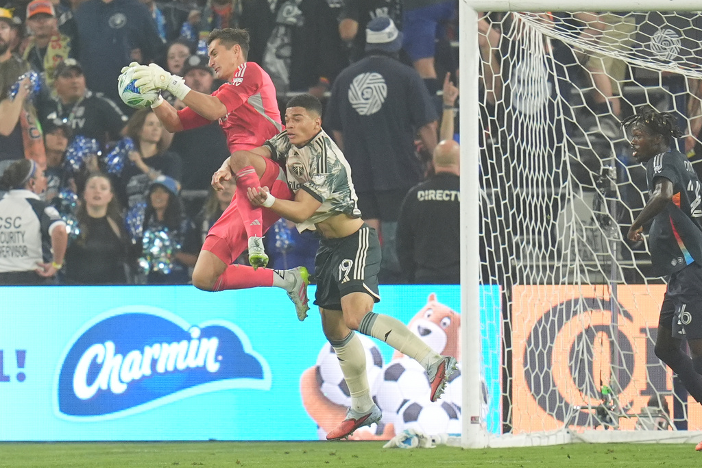 San Diego FC goalkeeper Pablo Sisniega grabs the ball in front of Portland Timbers forward Kevin Kelsy during the first half of Game 3 in the first round of MLS soccer's Western Conference playoffs Sunday, Nov. 9, 2025, in San Diego. (AP Photo/Gregory Bull)