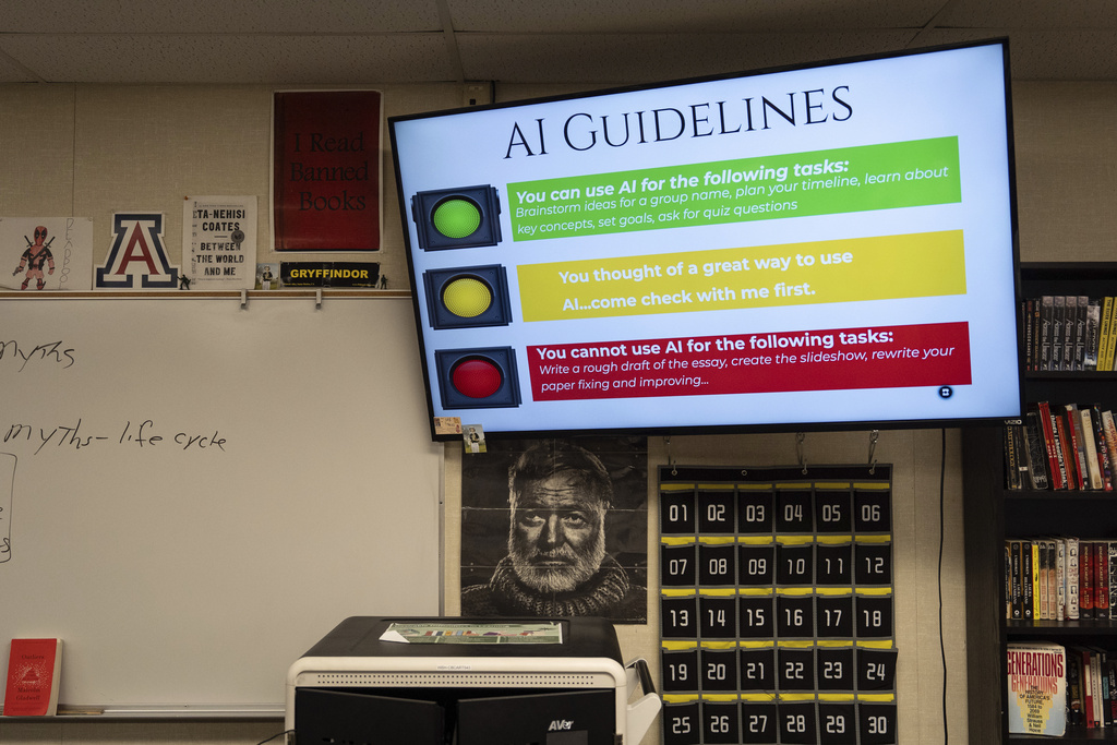 A screen displays guidelines for using artificial intelligence above a portrait of Ernest Hemingway in Casey Cuny's English class at Valencia High School in Santa Clarita, Calif., Wednesday, Aug. 27, 2025. (AP Photo/Jae C. Hong)