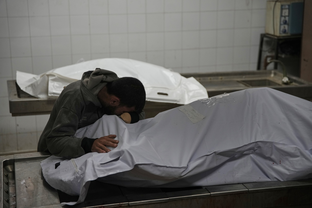 Magdi Abu Al-Khair bids farewell to his mother, Amal Abu Al-Khair, after she and her grandchild, Saud, were killed when their tent caught fire overnight at the Yarmouk displacement camp, at Al-Shifa Hospital in Gaza City, Friday, Jan. 2, 2026. (AP Photo/Jehad Alshrafi)