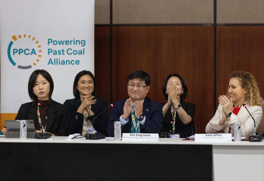 Kim Sung-hwan, center, the inaugural head of South Korea's new Ministry of Climate, Energy and Environment, applauds after he made the announcement of South Korea joining the Powering Past Coal Alliance, during U.N. climate talks in Belem, Brazil, Nov. 17, 2025. (AP Photo/Anton L. Delgado)