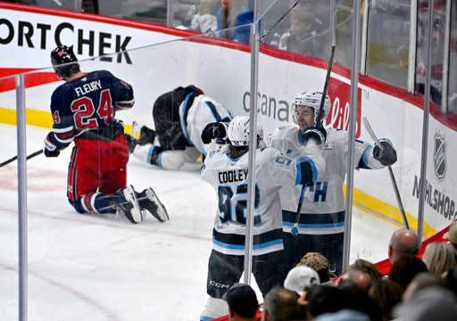 Utah Mammoth's Dylan Guenther (11) celebrates after the winning goal against the Winnipeg Jets with Logan Cooley (92) during the third period of an NHL hockey game in Winnipeg, Manitoba, Sunday, Oct. 26, 2025. (Fred Greenslade/The Canadian Press via AP) Utah Mammoth's Dylan Guenther (11) celebrates after the winning goal against the Winnipeg Jets with Logan Cooley (92) during the third period of an NHL hockey game in Winnipeg, Manitoba, Sunday, Oct. 26, 2025. (Fred Greenslade/The Canadian Press via AP)