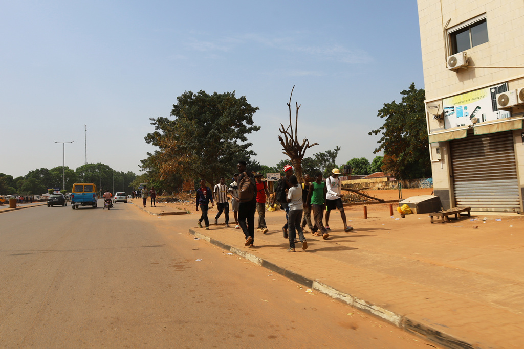 People walk on the street in Bissau, Guinea-Bissau, Wednesday, Nov. 26, 2025. (AP Photo/Darcicio Barbosa)