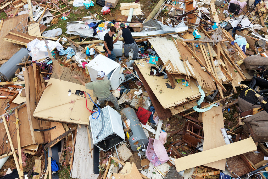 People move debris at Gene's Mobile Home Supply, a trailer park in Bogue Chitto, Miss., Thursday, May, 7, 2026, after a tornado cut across the state. (AP Photo/Gerald Herbert)