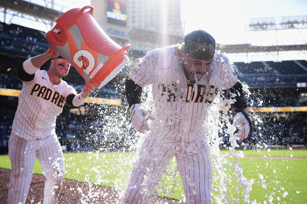 San Diego Padres' Luis Campusano, right, is doused by teammate Ty France after Campusano hit a walk off single and. the Padres defeated the Milwaukee Brewers 4-3 in a baseball game Wednesday, Aug. 12, 2026, in San Diego. (AP Photo/Gregory Bull)