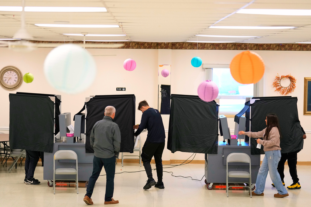 Poll workers help people get set up to vote at a polling site in Garfield, N.J., Tuesday, Nov. 4, 2025. (AP Photo/Seth Wenig)
