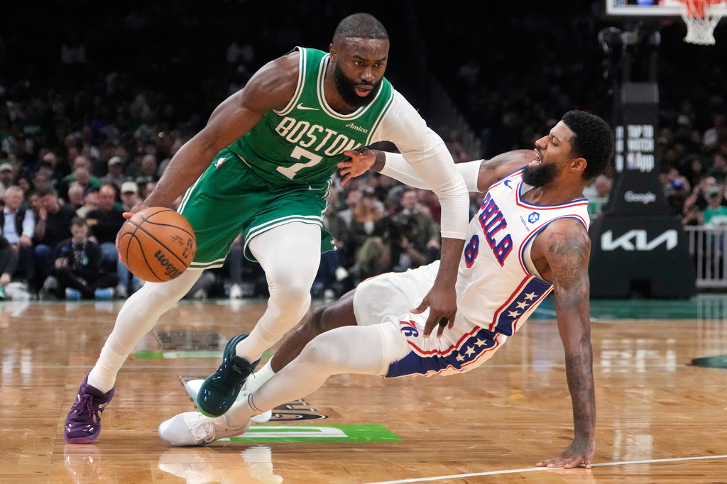 FILE - Boston Celtics guard Jaylen Brown (7) drives to the basket against Philadelphia 76ers forward Paul George (8) during the first half of Game 2 of a first-round NBA playoffs basketball series, April 21, 2026, in Boston. (AP Photo/Charles Krupa, File)