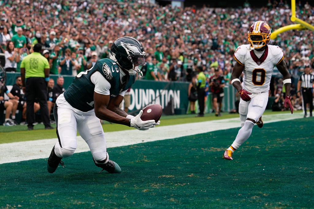Philadelphia Eagles wide receiver Dontayvion Wicks (13) catches a pass for a touchdown in front of Washington Commanders cornerback Mike Sainristil (0) during the first half of an NFL football game, Sunday, Sept. 13, 2026, in Philadelphia. (AP Photo/Matt Slocum)