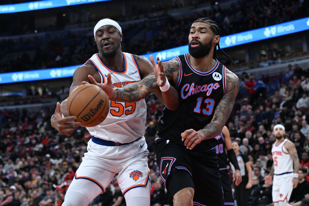 New York Knicks' Ariel Hukporti (55) battles Chicago Bulls' Nick Richards (13) for a loose ball during the first half of an NBA basketball game, Sunday, Feb. 22, 2026, in Chicago. (AP Photo/Paul Beaty)