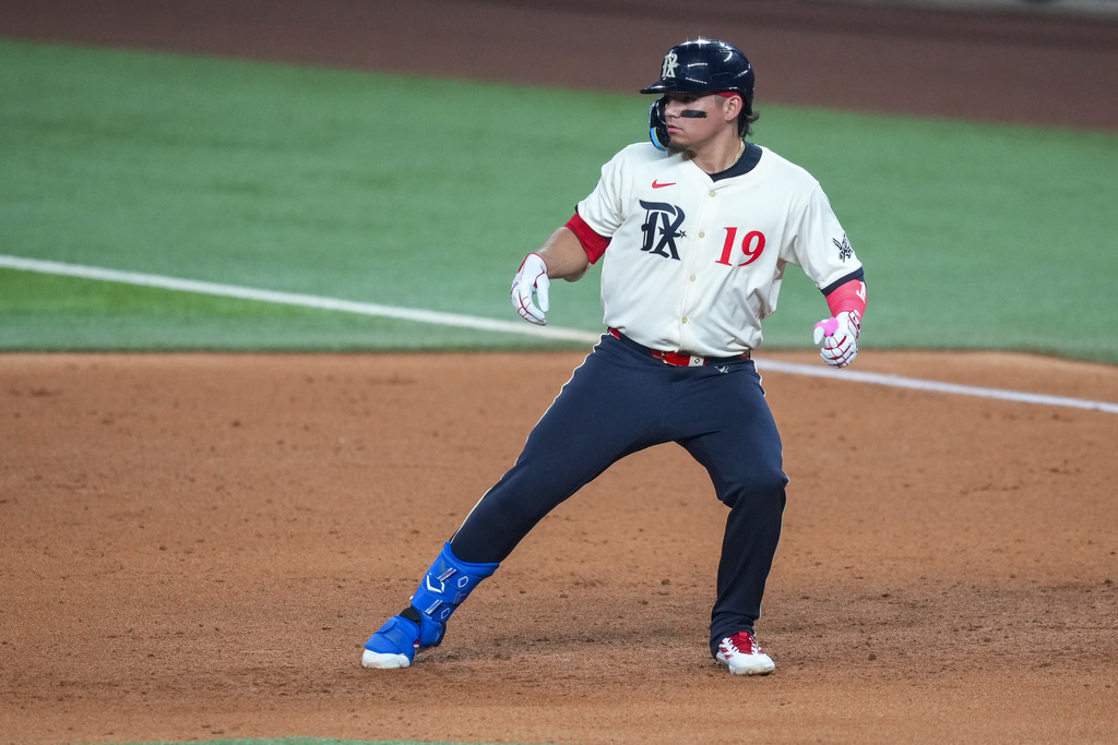 Texas Rangers' Alejandro Osuna turns the base while running out a single against the Miami Marlins during the sixth inning of a baseball game Friday, Sept. 19, 2025, in Arlington, Texas. (AP Photo/Julio Cortez)