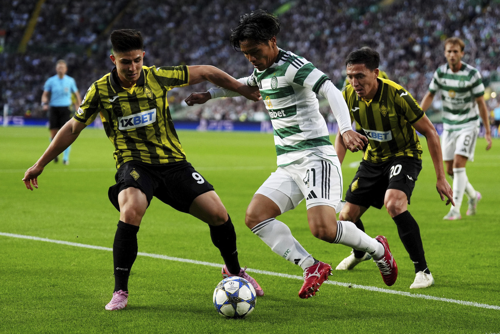 Kairat's Dastan Satpayev, left, and and Celtic's Reo Hatate battle for the ball during the UEFA Champions League playoff first leg soccer match at Celtic Park, Wednesday, Aug. 20, 2025, in Glasgow, Scotland. (Andrew Milligan/PA via AP)