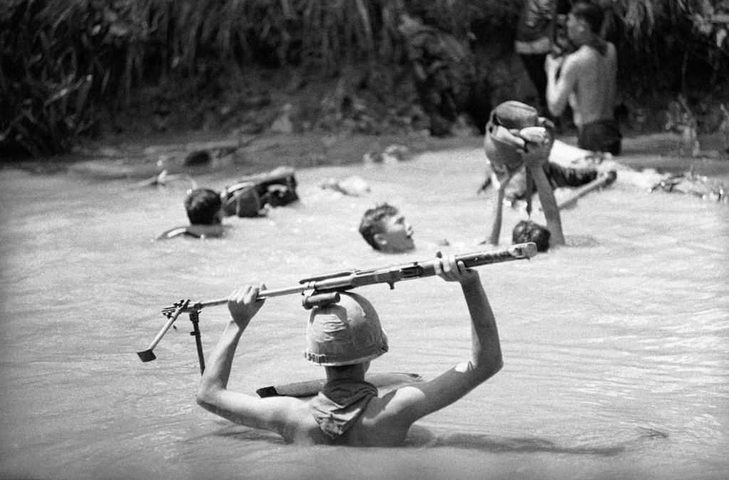 FILE - A South Vietnamese Ranger holds his rifle above water as he crosses a canal in the Kien Hoa province in the Mekong Delta, South Vietnam on July 13, 1967, while his shorter comrades are up to their chins in water. (AP Photo/Dang Van Phuoc, File)