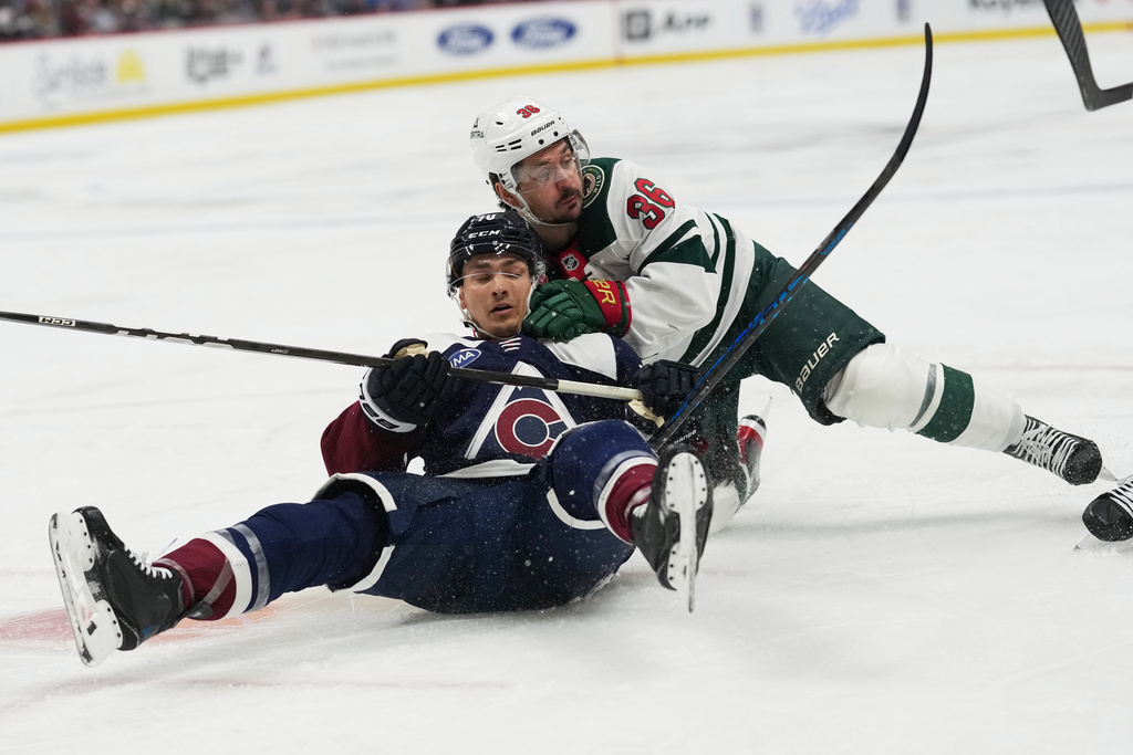 Colorado Avalanche defenseman Sam Malinski, left, tumbles to the ice with Minnesota Wild right wing Mats Zuccarello while pursuing the puck n the second period of an NHL hockey game, Thursday, Feb. 26, 2026, in Denver. (AP Photo/David Zalubowski)