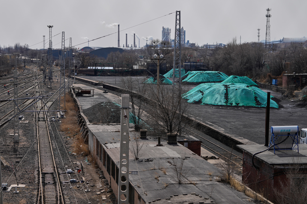 Piles of coal are covered up near train tracks in Datong, China, Saturday, March 14, 2026. (AP Photo/Ng Han Guan)