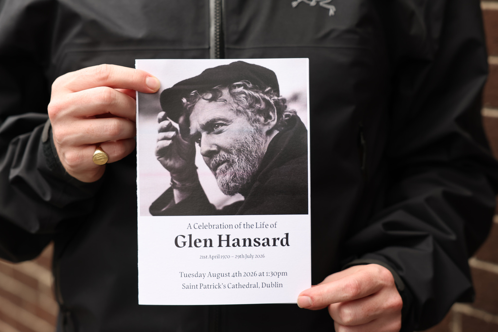 The Order of Service is held up ahead of the funeral of Glen Hansard at St Patrick's Cathedral in Dublin, Tuesday, Aug. 4, 2026. (Damien Eagers/PA via AP)