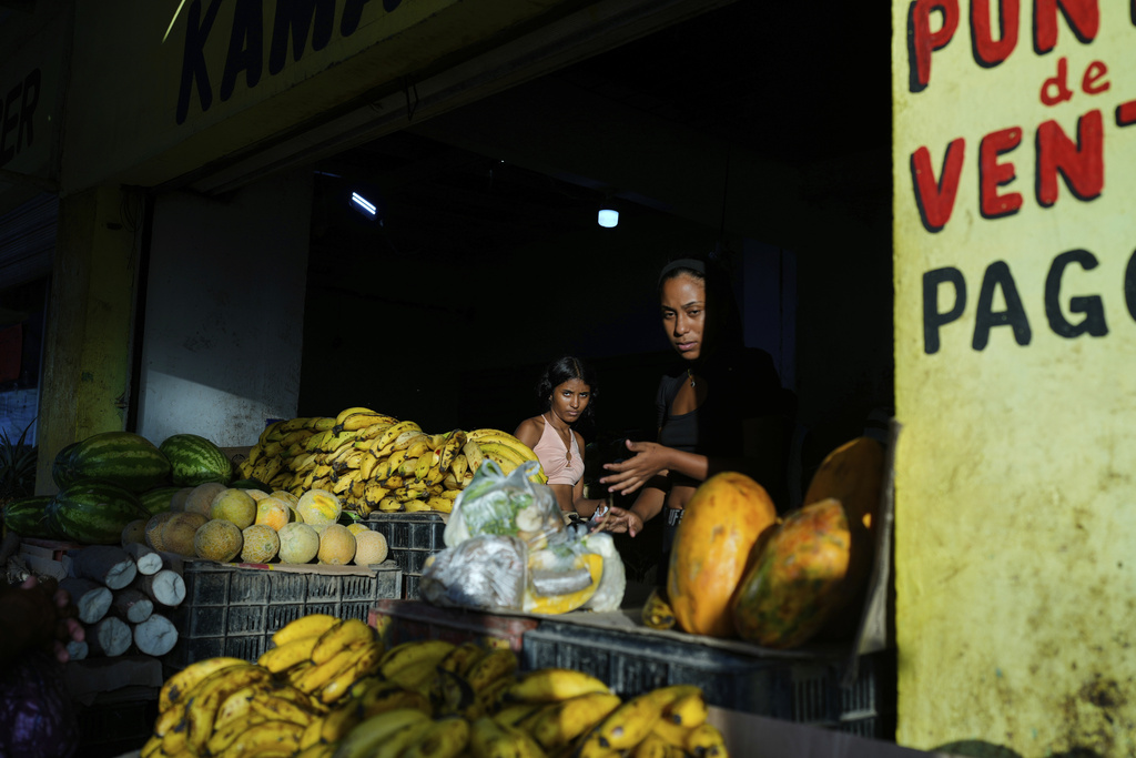 People buy vegetables in Coro, Venezuela, Saturday, June 28, 2025. (AP Photo/Ariana Cubillos)