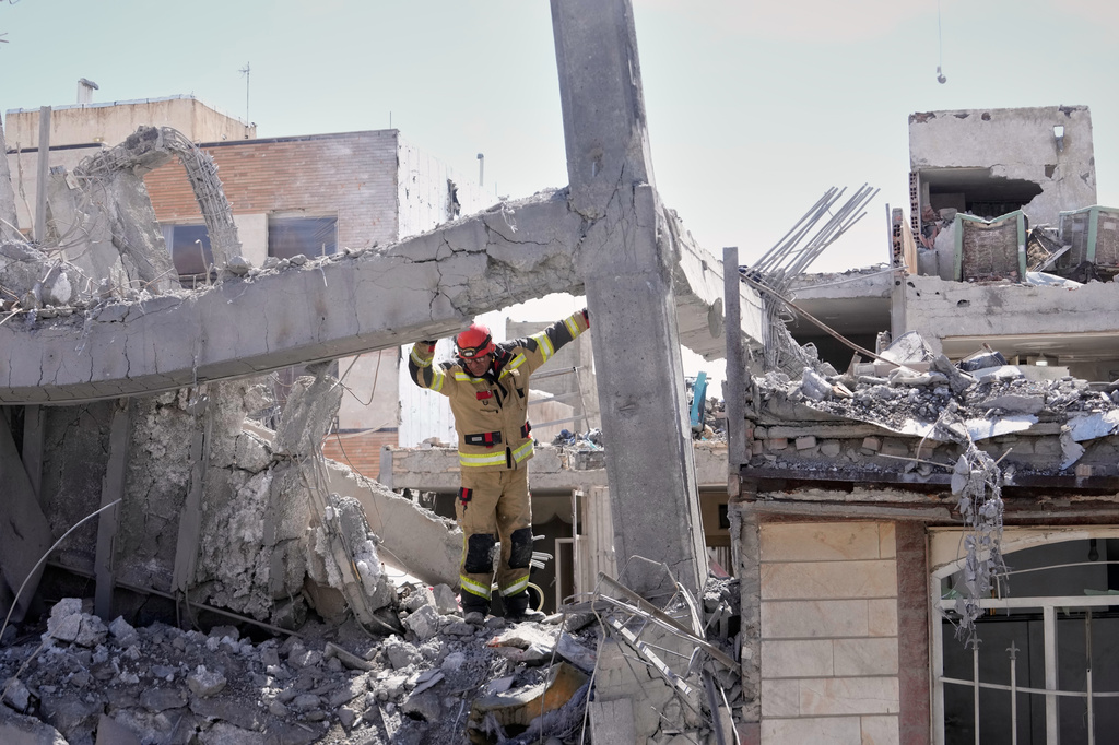 A first responder inspects the damaged structure of a residential building hit in an earlier U.S.-Israeli strike in Tehran, Friday, March 27, 2026. (AP Photo/Vahid Salemi)