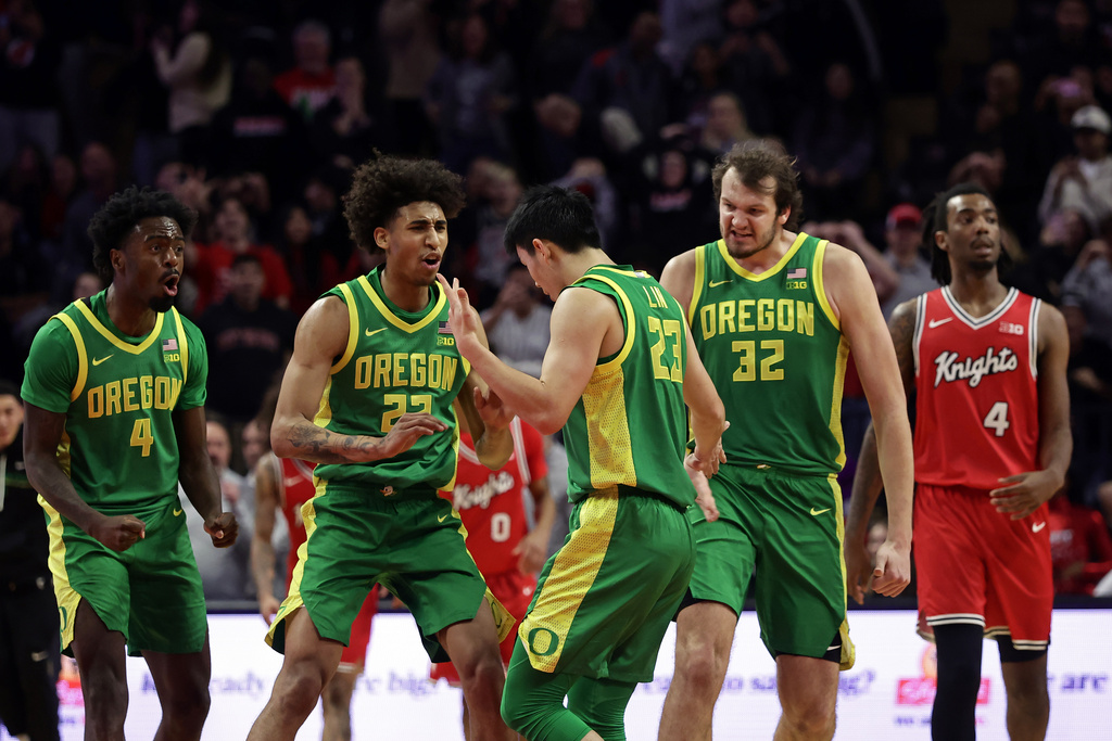 Oregon guard Wei Lin (23) celebrates with forward Devon Pryor (22) after hitting a 3-point basket to send an NCAA college basketball game against Rutgers into overtime Monday, Jan. 5, 2026, in Piscataway, N.J. (AP Photo/Adam Hunger)