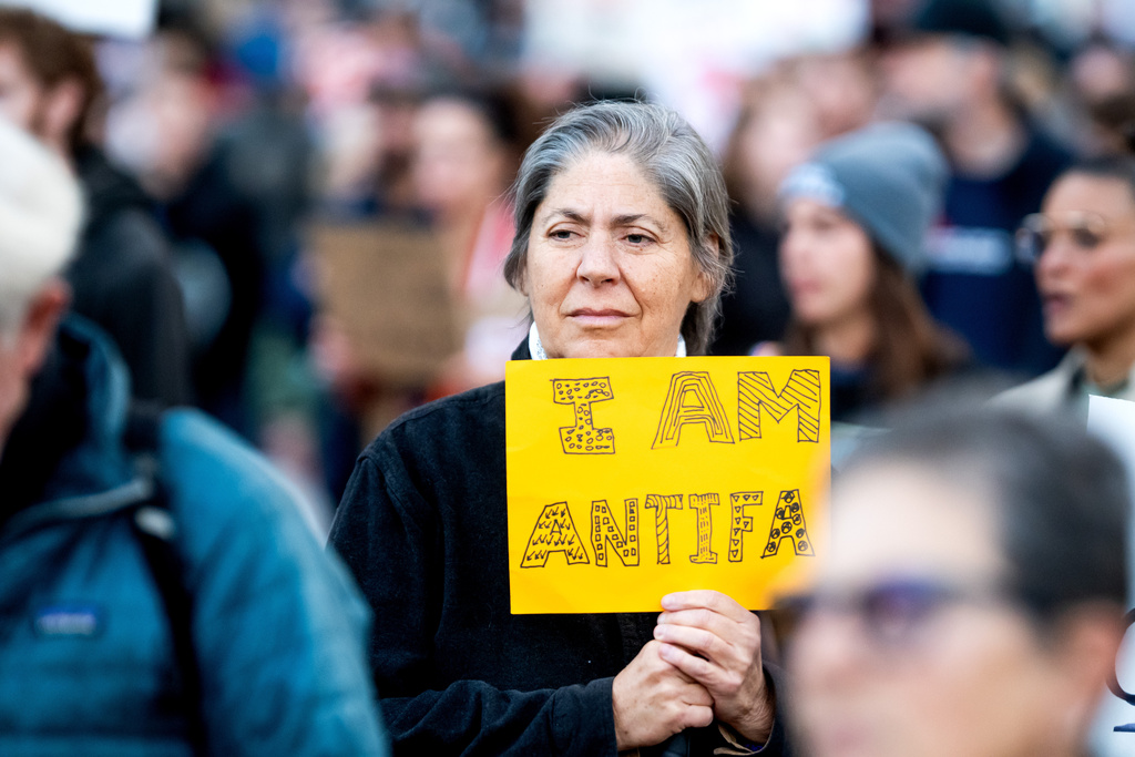 Max Ventura holds a sign reading "I AM ANTIFA" while protesting against immigration raids in San Francisco on Thursday, Oct. 23, 2025. (AP Photo/Noah Berger)